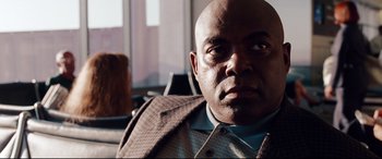 Movie still from “The Insider” (1999), directed by Michael Mann – A man with a bald head wearing a suit jacket; Close Up shot, Low angle