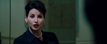 Movie still from “The Insider” (1999), directed by Michael Mann – A person wearing a suit and pearls; Close Up shot, Over the shoulder angle
