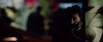 Movie still from “The Insider” (1999), directed by Michael Mann – A person with a headset in a dark room; Close Up shot, Over the shoulder angle