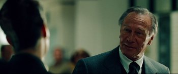 Movie still from “The Insider” (1999), directed by Michael Mann – An older man wearing a suit and tie; Close Up shot, Over the shoulder angle