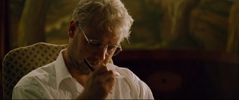 Movie still from “The Insider” (1999), directed by Michael Mann – A man with glasses is holding a pen in his mouth; Close Up shot, Low angle