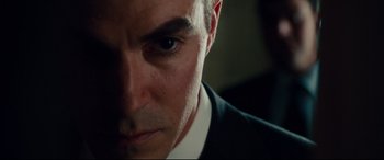 Movie still from “The Insider” (1999), directed by Michael Mann – A man in a black suit; Extreme Close Up shot, Low angle