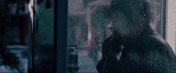 Movie still from “The Insider” (1999), directed by Michael Mann – A person standing in front of a window in the snow; Extreme Close Up shot, Over the shoulder angle