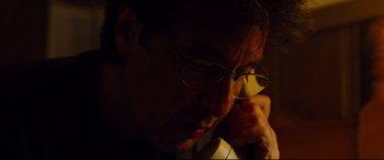 Movie still from “The Insider” (1999), directed by Michael Mann – A person wearing glasses looking down; Close Up shot, High angle