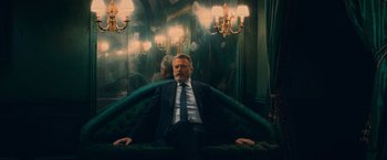 A man in a suit and tie sitting on a couch