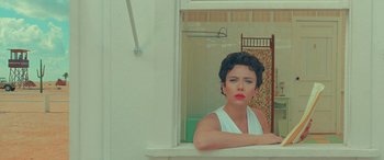 Movie still from “Asteroid City” (2023), directed by Wes Anderson – A woman standing in front of a bathroom window; Medium shot, High angle