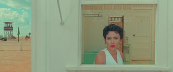 Movie still from “Asteroid City” (2023), directed by Wes Anderson – A woman is looking out of a bathroom window; Medium shot, High angle
