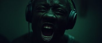 A person with headphones on and a mouth wide open