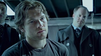 Movie still from “Avatar” (2009), directed by James Cameron – A man in a black shirt and a man in a black suit; Close Up shot, Over the shoulder angle