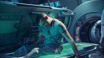 Movie still from “Avatar” (2009), directed by James Cameron – A man sitting on the floor of a spaceship; Wide shot, Overhead angle