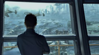 Movie still from “Avatar” (2009), directed by James Cameron – A man looking out of a window at an airport; Wide shot, Over the shoulder angle