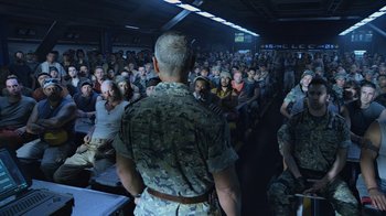 Movie still from “Avatar” (2009), directed by James Cameron – A group of people sitting in front of a man in military fatigues; Wide shot, High angle