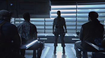 Movie still from “Avatar” (2009), directed by James Cameron – A group of people sitting in a room; Wide shot, Over the shoulder angle