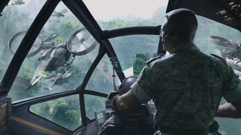 Movie still from “Avatar” (2009), directed by James Cameron – A man in a military uniform sitting in the cockpit of a helicopter; Wide shot, High angle