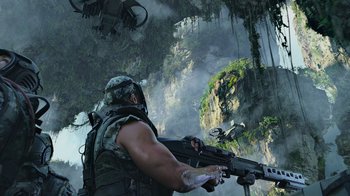 Movie still from “Avatar” (2009), directed by James Cameron – A man with a gun in a jungle with birds flying overhead; Wide shot, Low angle