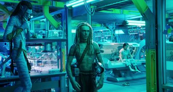 Movie still from “Avatar: The Way of Water” (2022), directed by James Cameron – A man with dreadlocks is standing in a room; Wide shot, Low angle