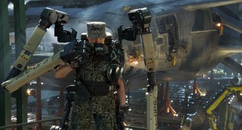 Movie still from “Avatar: The Way of Water” (2022), directed by James Cameron – A man in a military uniform is holding a gun; Wide shot, Low angle