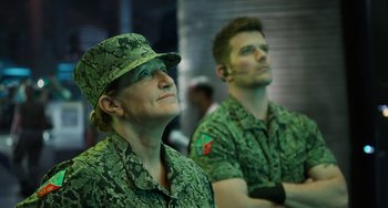 Movie still from “Avatar: The Way of Water” (2022), directed by James Cameron – A couple of men in green military fatigues and hats; Medium shot, Over the shoulder angle