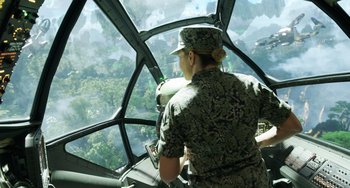 Movie still from “Avatar: The Way of Water” (2022), directed by James Cameron – A woman in a military uniform looking out a window; Wide shot, High angle