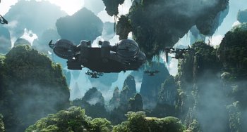 Movie still from “Avatar: The Way of Water” (2022), directed by James Cameron – A group of people flying over a lush green forest; Extreme Wide shot, Low angle