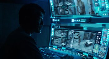 Movie still from “Avatar: The Way of Water” (2022), directed by James Cameron – A man sitting in front of a computer monitor; Medium shot, Over the shoulder angle