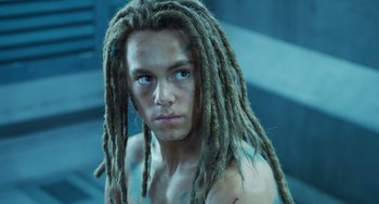 Movie still from “Avatar: The Way of Water” (2022), directed by James Cameron – A man with dreadlocks is staring straight ahead; Close Up shot, Overhead angle