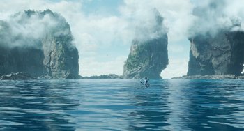 Movie still from “Avatar: The Way of Water” (2022), directed by James Cameron – A person on a surfboard in the water; Extreme Wide shot, High angle