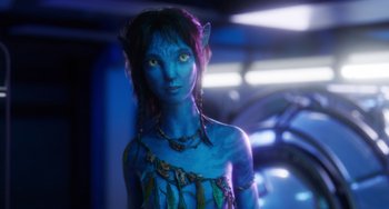 Movie still from “Avatar: The Way of Water” (2022), directed by James Cameron – A woman with blue skin and yellow eyes; Medium shot, Over the shoulder angle