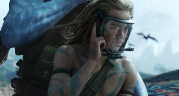 Movie still from “Avatar: The Way of Water” (2022), directed by James Cameron – A man with dreadlocks is holding a cell phone to his ear; Close Up shot, Low angle
