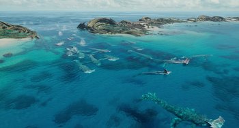 Movie still from “Avatar: The Way of Water” (2022), directed by James Cameron – An aerial view of an ocean with a bunch of sharks swimming in it; Extreme Wide shot, High angle