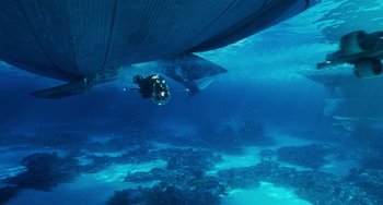 Movie still from “Avatar: The Way of Water” (2022), directed by James Cameron – A scuba diver is under a boat in the ocean; Extreme Wide shot, High angle