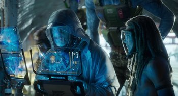 Movie still from “Avatar: The Way of Water” (2022), directed by James Cameron – A man holding a computer screen in a room; Medium shot, Over the shoulder angle