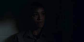 Movie still from “Awake” (2021), directed by Mark Raso – A woman in the dark looking at the camera; Close Up shot, Low angle