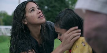 Movie still from “Awake” (2021), directed by Mark Raso – A young woman holding the ear of a young girl; Close Up shot, Over the shoulder angle