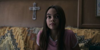 Movie still from “Awake” (2021), directed by Mark Raso – A young girl sitting in front of a crucifix; Close Up shot, Over the shoulder angle