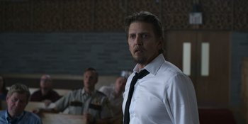 Movie still from “Awake” (2021), directed by Mark Raso – A man wearing a white shirt and a black tie; Medium shot, Over the shoulder angle