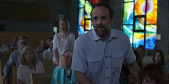 Movie still from “Awake” (2021), directed by Mark Raso – A man standing in front of a group of people; Medium shot, Low angle