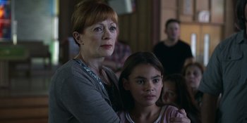 Movie still from “Awake” (2021), directed by Mark Raso – A woman standing next to a young girl in a room; Close Up shot, Over the shoulder angle