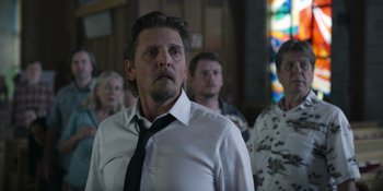 Movie still from “Awake” (2021), directed by Mark Raso – A group of people standing in front of a stained glass window; Close Up shot, Low angle