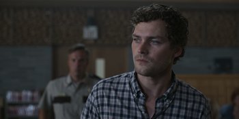 Movie still from “Awake” (2021), directed by Mark Raso – A man in a checkered shirt looking at the camera; Close Up shot, Low angle