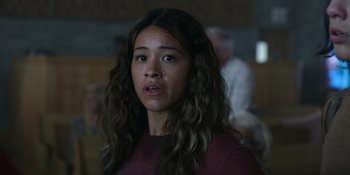 Movie still from “Awake” (2021), directed by Mark Raso – A woman with long brown hair is looking at the camera; Close Up shot, Over the shoulder angle