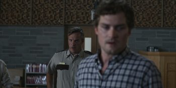 Movie still from “Awake” (2021), directed by Mark Raso – Two men are standing next to each other in a room; Close Up shot, Over the shoulder angle