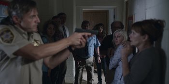 Movie still from “Awake” (2021), directed by Mark Raso – A group of people standing in a room; Medium shot, Over the shoulder angle