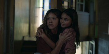 Movie still from “Awake” (2021), directed by Mark Raso – Two young girls are hugging in a room; Close Up shot, Low angle