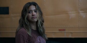 Movie still from “Awake” (2021), directed by Mark Raso – A young woman with long hair looking sad; Close Up shot, Over the shoulder angle