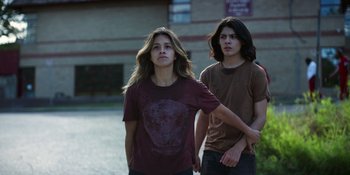 Movie still from “Awake” (2021), directed by Mark Raso – Two young people standing next to each other on the street; Medium shot, Low angle