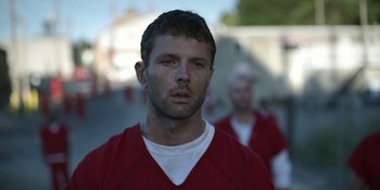 Movie still from “Awake” (2021), directed by Mark Raso – A person wearing a red shirt; Close Up shot, Low angle