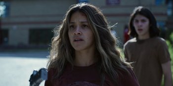 Movie still from “Awake” (2021), directed by Mark Raso – A woman with long brown hair is looking at the camera; Close Up shot, Over the shoulder angle
