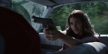 Movie still from “Awake” (2021), directed by Mark Raso – A woman holding a gun in a vehicle; Close Up shot, Low angle