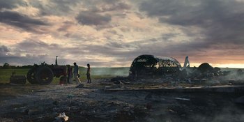 Movie still from “Awake” (2021), directed by Mark Raso – A group of people standing next to an abandoned structure; Extreme Wide shot, Low angle